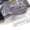 Dunkles Kleidungsstück in einer ECOBAGS® Textilverpackung mit Aufdruck